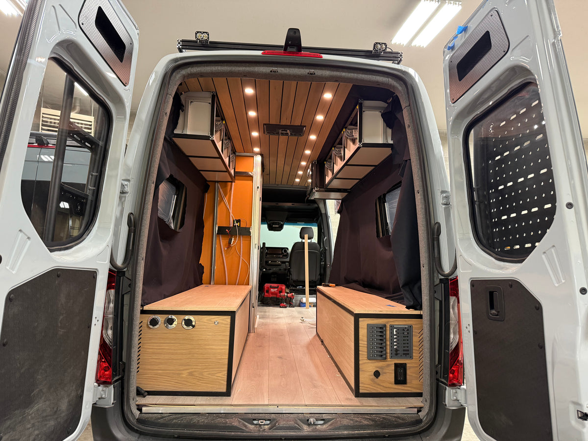 Close-up of a black 1/4 inch hexply rear cargo door cubby installed in a Mercedes Sprinter conversion.